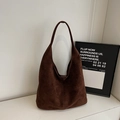 Detail einer dunkelbraunen Wildleder-Hobo-Tasche mit weicher Vintage-Textur und Trageriemen - Kaffeebraun