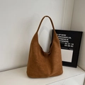 Detaillierte Makroansicht der dunkelbraunen Wildlederoptik und Naht der Hobo-Tasche - Braun