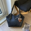 Close-up of black faux leather tote bag with a cute brown teddy bear charm and gold buckle - With Charm / Black