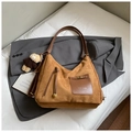 Detail van bruine suède hobo tas met lederen vak, kwastjes en een beer sleutelhanger - Bruin met Hanger