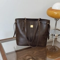 Borsa tote marrone minimalista con fibbia dorata e spalline sottili sulla tavola - Marrone