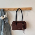Detail of coffee suede tote bag with brand print and woven charm on a wooden wall hook - With Pendant / Brown