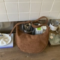 Dettaglio della borsa hobo in pelle scamosciata marrone con cuciture e tracolla regolabile - Marrone
