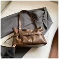 Detailopname van vintage bruine lederen tote bag met gesp op een colbertjasje - Bruin