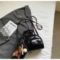 Detalle de bolso Boston en cuero negro brillante con llavero de béisbol y herrajes plateados - Negro Con Colgante