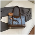 Blauwe denim en bruine leren draagtas met donutbedel op een grijze blazer gelegd - Blauw met Hanger