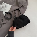 Detail of a minimalist black suede pleated handbag with smooth leather straps and silver buckle - Black