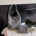 Detail der grauen Teddy-Stoff-Tasche mit passender Innentasche auf einem Bett - Grau