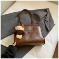 Detailed close-up of dark brown vintage PU leather bag with embossed text and bear charm - Brown with Pendant
