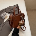 Borsa a secchiello marrone vintage con sciarpa a righe e ciondolo orso su blazer grigio - Marrone con ciondolo