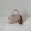 Détail du sac Boston crème avec texture cuir et petit pendentif ours décoratif - Blanc Avec Pendentif