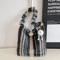Detail of plush multi-color striped tote bag with soft faux fur texture and eye charm - Blue