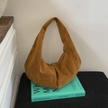 Dettaglio macro della borsa hobo in pelle scamosciata marrone con cerniera su libri - Marrone