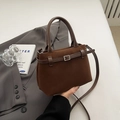 Detail of chocolate brown matte leather handbag with decorative metal buckle and strap - Brown