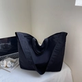 Close-up of a large black nylon tote bag with a laptop and headphones on a desk - Black