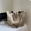 Detail of khaki nylon tote bag with wrinkled texture on a desk with a laptop - Khaki