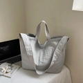 Detail of light gray nylon tote bag featuring cylindrical handles and wide shoulder strap - Off-White