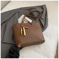 Detail van de donkerbruine geweven textuur op een tas met een kralenhanger accent - Met Hanger / Koffie Met Hanger