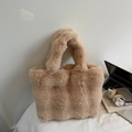 Detail of camel plush tote bag with thick fluffy handles next to a laptop and book - Khaki