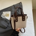 Beige canvas bucket bag with brown leather trim and adjustable gold-buckle strap - Coffee No Charm