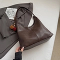 Detail van de grote donkerbruine emmertas met pluche hanger en gekleurde kralenaccessoire - Koffie Met Hanger
