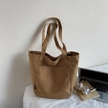 Detail view of the deep brown nylon tote bag with an outer pocket in a daily setting - Caramel color