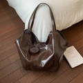 Deep brown oversized tote bag with polished oily faux leather texture and round charm - Brown