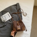 Brown leopard print bucket bag with leather strap and drawstring in lifestyle setting - Coffee No Charm