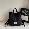 Minimalist black canvas bucket backpack with drawstring closure and brand label detail - Black