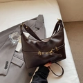 Minimalist vintage dark brown leather hobo bag with bronze buckle on white bedding - Brown