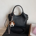 Detailansicht der schwarzen gewebten Handtasche mit Plüschwelpen-Anhänger und Gurt - Mit Anhänger / Schwarz