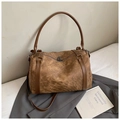 Brown vintage leather pillow bag with dual straps and textured finish on grey suit - Brown
