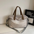 Detailansicht der Nylon-Reisetasche mit Markenlogo und verstärktem braunem Tragegriff - Einheitsgröße / Grau