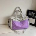 Detail der grauen Reisetasche mit lila karierter Tasche und verstellbarem Schultergurt - Lila