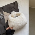 Detalle de bolso de peluche blanco sobre chaqueta gris con accesorios decorativos - Blanco Roto