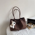 Detail of brown suede tote bag with puppy charm, laptop, and books for office style - Red Brown (With Charm)