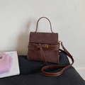 Detail of dark brown suede handbag with leather buckle closure and top handle strap - Brown