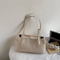 Detalle de bolso beige con correas ajustables y pequeña placa de marca elegante - Blanco Roto