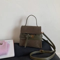 Detail of dark green suede handbag with decorative leather buckles and gold metal hardware - Green