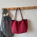 Detail of burgundy tote bag with fine shoulder straps on a wooden rack with denim jacket - Wine Red Without Pendant
