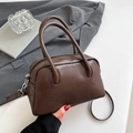 Close-up of retro brown Boston bag showing textured leather finish and silver hardware - Coffee without Pendant