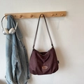 Close-up of vintage dark wine red suede tote bag with Banatu logo patch on wood hook - No Pendant / Coffee