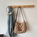 Detail view of light brown suede tote bag with cute puppy plush charm and leather strap - With Pendant / Khaki