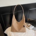 Große Hobo-Tasche in hellem Khaki mit Logo-Detail auf weißem minimalistischem Bett - Khaki