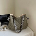 Detailed macro view of army green quilted tote bag with striped woven strap and large capacity - Green