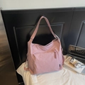 Détail du sac bandoulière en nylon rose montrant la texture imperméable et la fermeture - Rose
