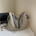 Detail of olive green quilted tote bag featuring a striped knot shoulder strap design - Off White