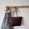 Detail of a chocolate quilted tote bag hanging with denim jacket and headphones - Coffee No Charm