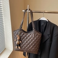Detailaufnahme der braunen Stepp-Tote-Bag mit süßem Hasen-Anhänger und Fashion-Logo - Kaffee Mit Anhängern