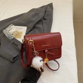 Detail of burgundy leather crossbody bag with fashion lettering and cute white plush charm - Red with Pendant